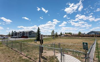 a fenced in grassy area with houses in the background